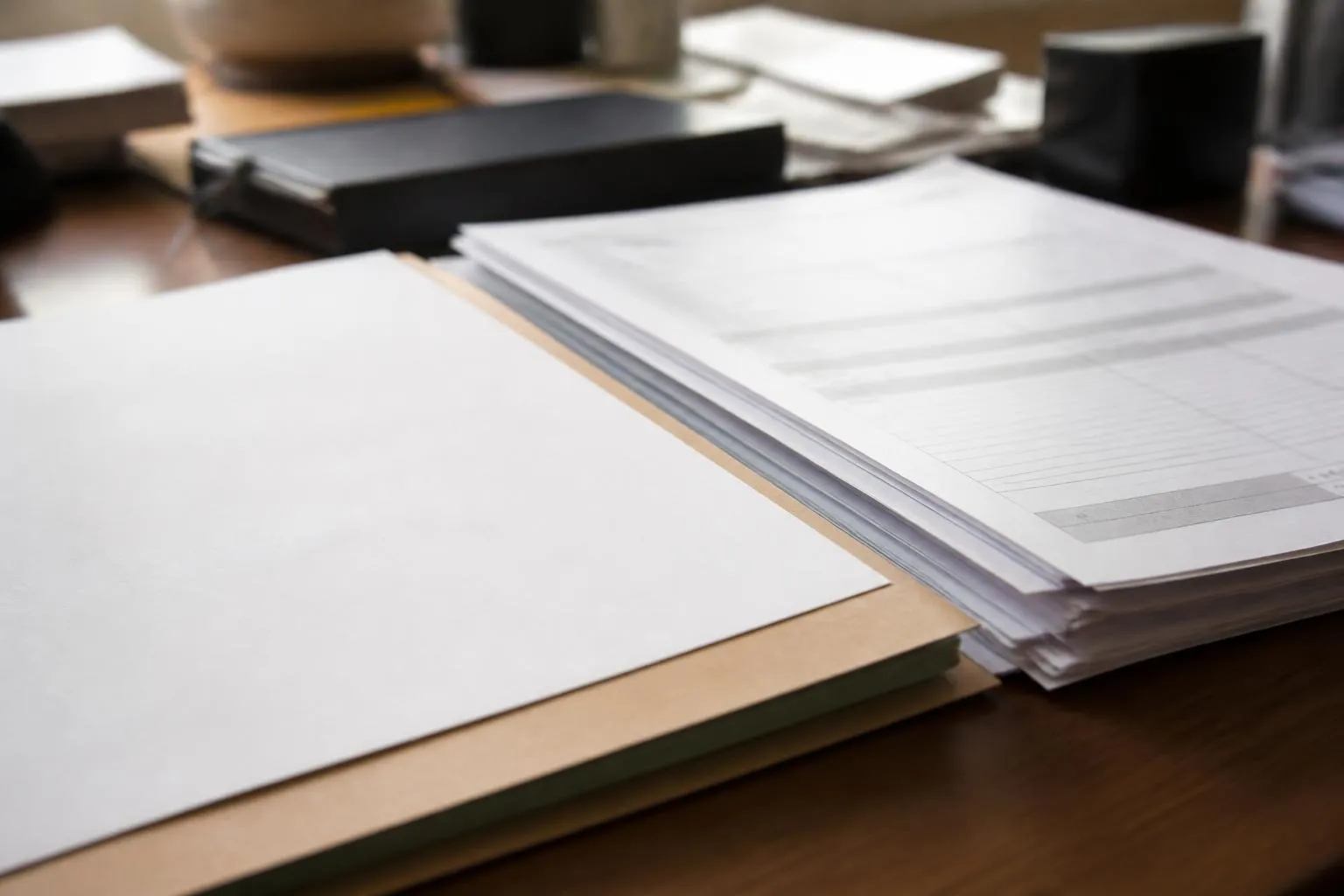 Une pile de fiches de paie et une attestation employeur posées sur un bureau de régie