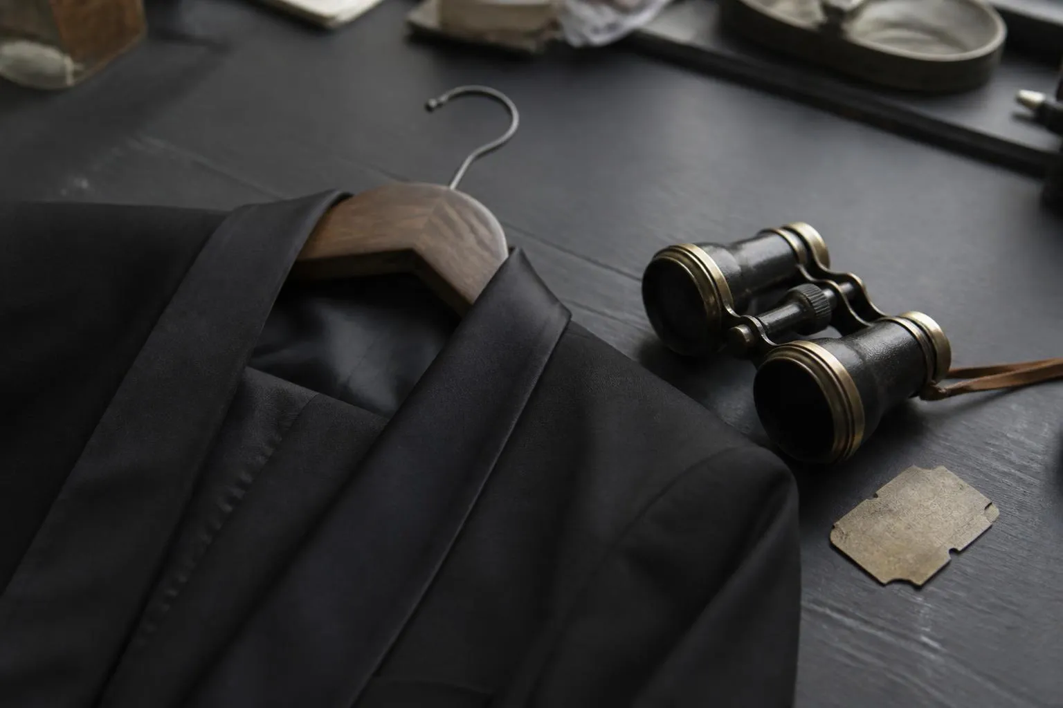 Smoking noir et nœud papillon sur un cintre, pistolet factice posé à côté